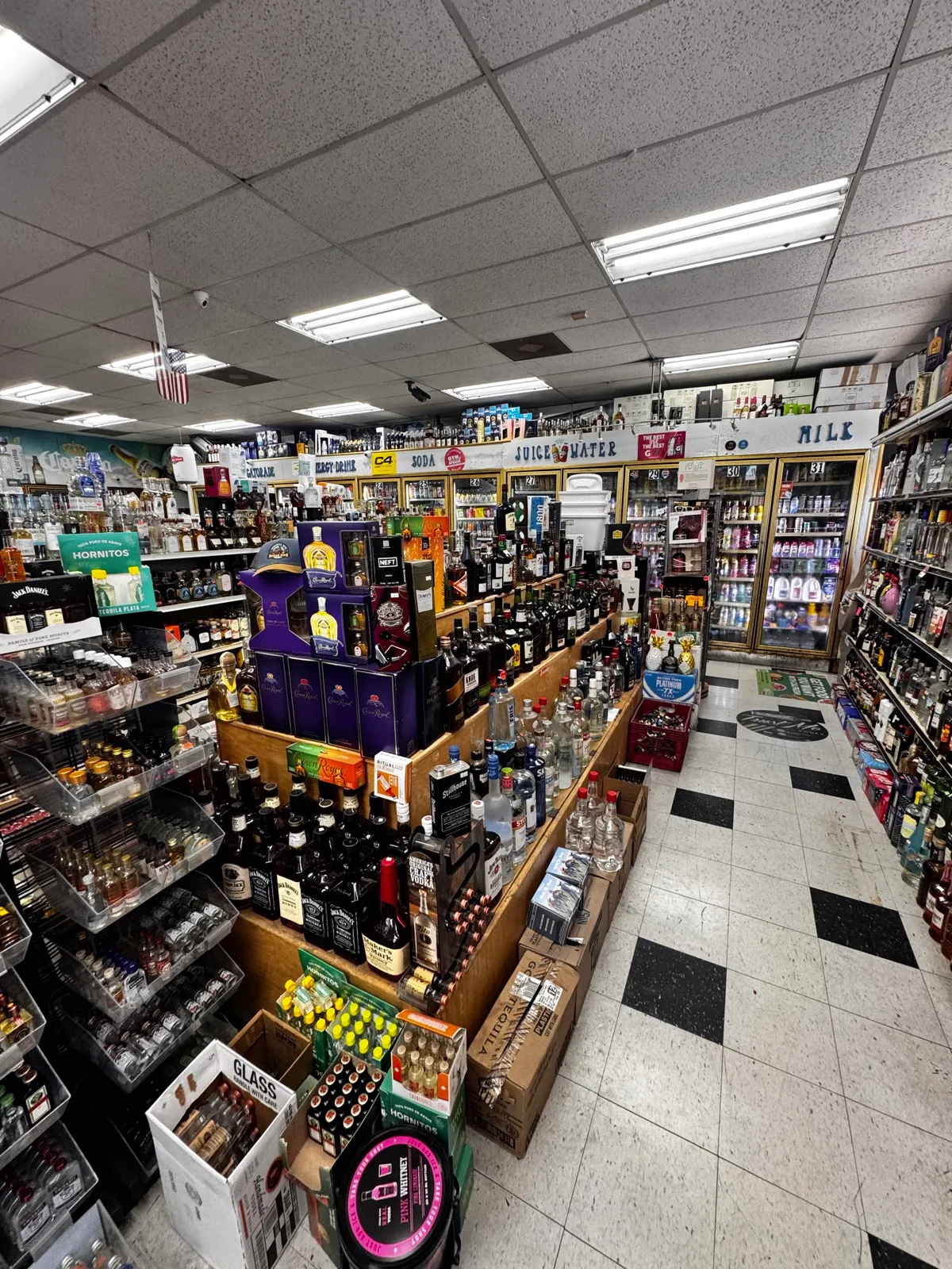 Inside the store — center islands of spirits with coolers along the walls